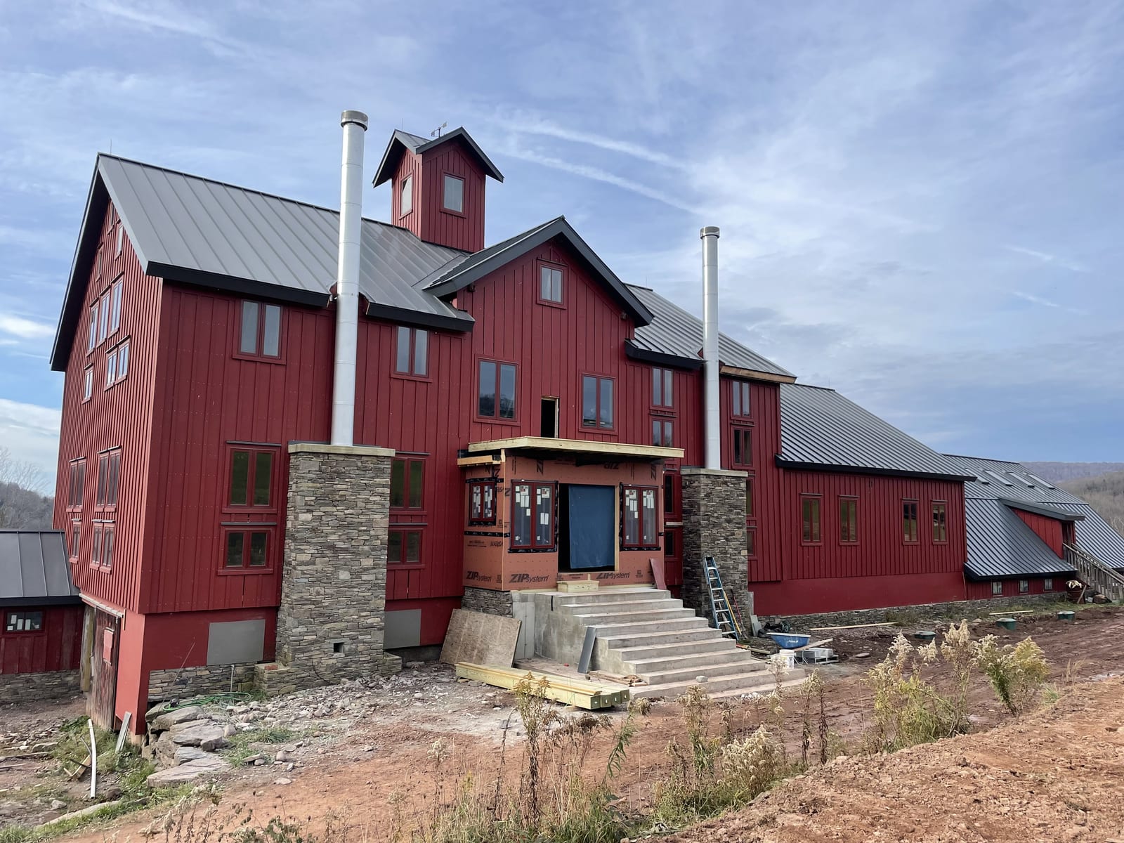 The farm's large stone-based timber barn standing against the hills of Andes, New York
